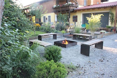 Feuerplatz mit Feuerstelle und Bänken aus Stahl und Holz